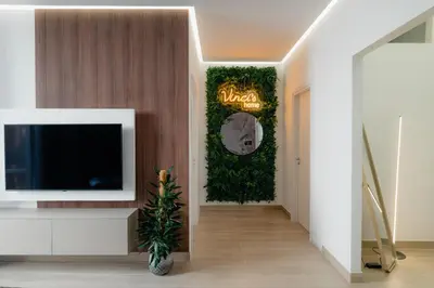 a hallway with a tv and a green wall at Vincis Home in Palermo