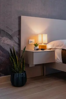 a bedroom with a bed and a table with a plant at Vincis Home in Palermo