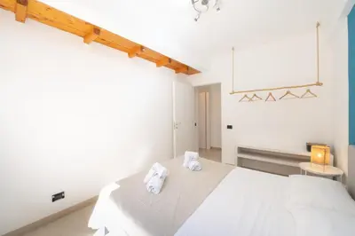 a white bedroom with two towels on a bed at Villa Azzurra in Scopello