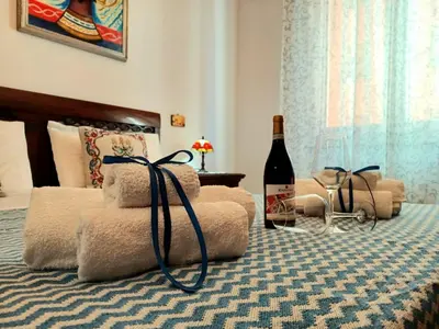 a bottle of wine sitting on top of a bed at House Via Napoli in Palermo