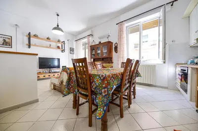 a dining room with a table and chairs and a television at House Via Napoli in Palermo
