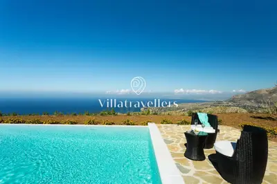 an image of a swimming pool with chairs and the ocean at Cava in Scopello