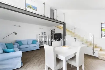 a white dining room with a white table and chairs at Cava in Scopello