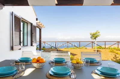 a table with blue plates and bowls of fruit on it at Cava in Scopello
