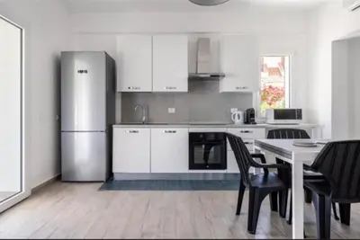 a kitchen with a refrigerator and a table with chairs at la villetta sul mare in Palermo