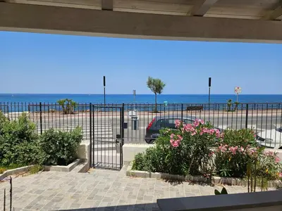 a balcony with a view of the beach and a car at la villetta sul mare in Palermo