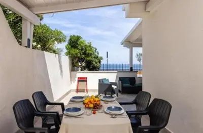 a table with chairs and fruit on a patio at la villetta sul mare in Palermo