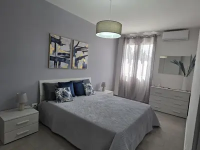 a bedroom with a bed with blue pillows at A Casa di Angela in Capaci