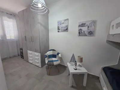 a white room with a chair and a table at A Casa di Angela in Capaci