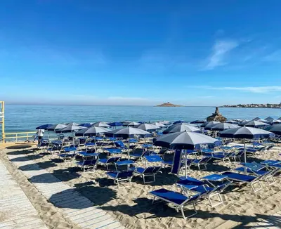 a bunch of chairs and umbrellas on a beach at A Casa di Angela in Capaci