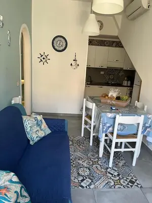 a living room with a blue couch and a table at Casa vacanza galatea San vito lo capo in San Vito lo Capo