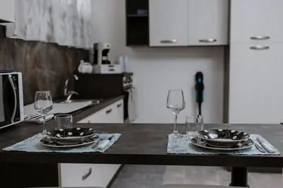 a kitchen with a table with glasses and plates on it at House Paradise- House Arena in Porticello