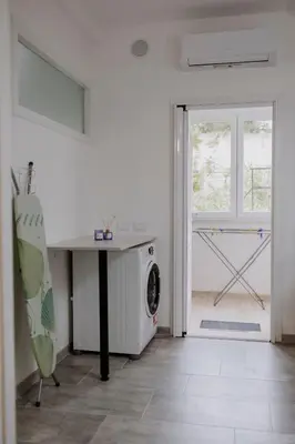 a laundry room with a washing machine and a window at House Paradise- House Arena in Porticello