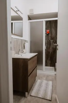 a bathroom with a sink and a shower at House Paradise- House Arena in Porticello