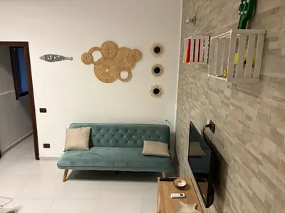 a living room with a green couch and a wall at Kiko Dodi House Mondello in Palermo