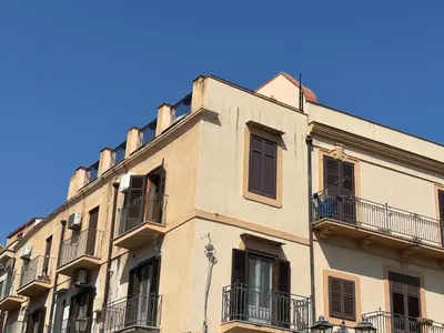 a tall building with balconies and a blue sky at Casa Vacanze Mazzini, amazing Rooftop! in Termini Imerese