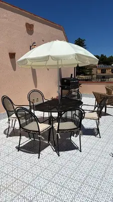 a table and chairs with a large umbrella at Casa Vacanze Mazzini, amazing Rooftop! in Termini Imerese