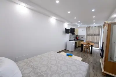 a bedroom with a bed and a kitchen with a table at Ummi Taliari in Terrasini