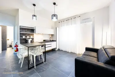 a kitchen and living room with a couch and a table at Calatafimi House in Palermo