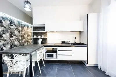a kitchen with white cabinets and a table and chairs at Calatafimi House in Palermo