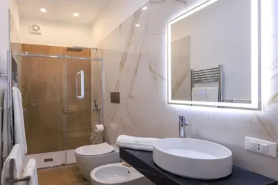 a bathroom with a sink and a toilet and a mirror at Suites Santa Cecilia in Palermo