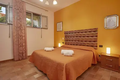 a bedroom with a bed with two towels on it at Casa vacanza Onda Lunga in Alcamo