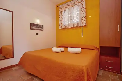 a bedroom with a bed with two towels on it at Casa vacanza Onda Lunga in Alcamo