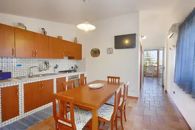 a kitchen with a wooden table and a dining room at Casa vacanza Onda Lunga in Alcamo