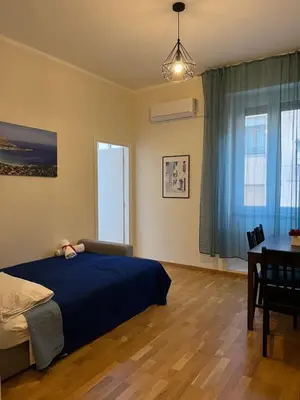 a bedroom with a bed and a table and window at Matteo's House in Palermo
