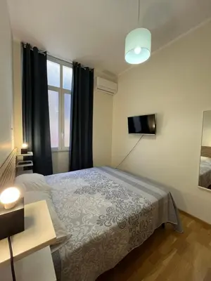a bedroom with a bed and a television in it at Matteo's House in Palermo