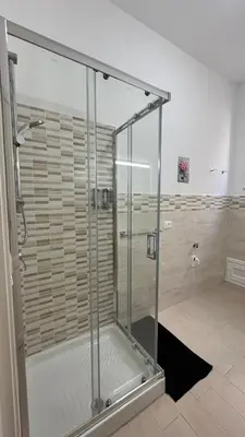 a shower with a glass door in a bathroom at Matteo's House in Palermo