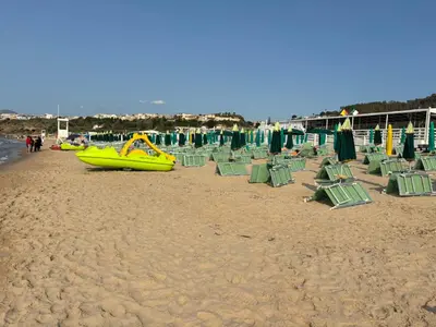 a beach with green chairs and a yellow slide at Casa Miramara Sicilia in Balestrate