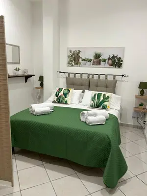 a green bed with pillows on it in a room at Sweet World in Terrasini