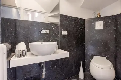 a bathroom with a sink and a toilet at Mani San Domenico by DomuSicily in Palermo