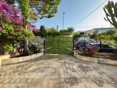 a gate in a driveway with pink flowers at Merlo Holiday Homes Mare in Trabia