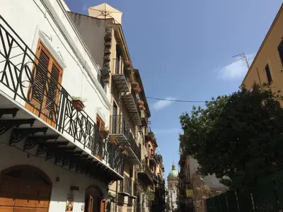 a narrow street with buildings and a blue sky at Casa Ballarò Centro Storico in Palermo