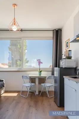 a kitchen with a table and chairs and a window at Baida Apartments in Palermo