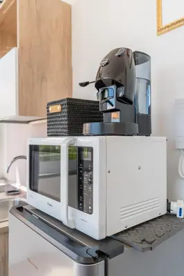 a coffee machine sitting on top of a microwave on a counter at Baida Apartments in Palermo
