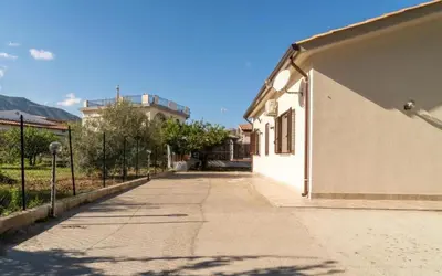 an empty sidewalk next to a building with a fence at Villa a due passi dal mare in Mandra Capreria
