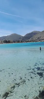 a person standing in the water on a beach at Oasi Mondello in Mondello