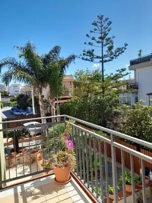 a balcony with potted plants and trees on it at Oasi Mondello in Mondello