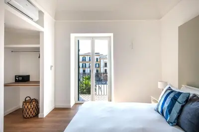 a white bedroom with a bed and a window at Ci' Capo Apartments by Wonderful Italy in Palermo