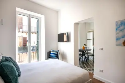 a bedroom with a bed and a window and a table at Ci' Capo Apartments by Wonderful Italy in Palermo