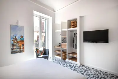 a bedroom with a bed and a flat screen tv at Ci' Capo Apartments by Wonderful Italy in Palermo