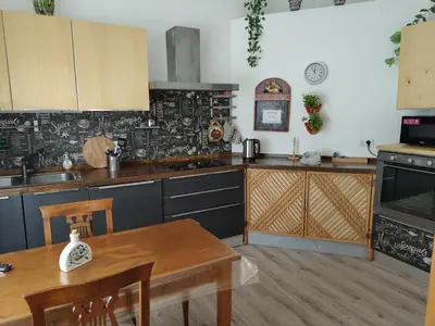 a kitchen with wooden cabinets and a table with a dining room at Sedie Volanti Classy Home in Palermo