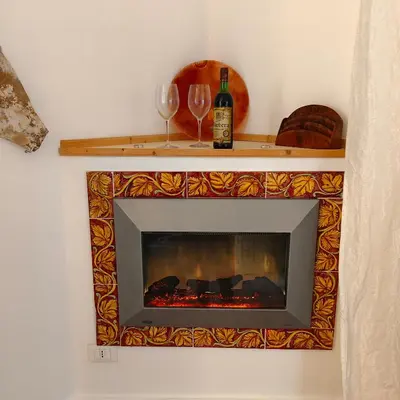 a fireplace with two glasses and a bottle of wine at Sedie Volanti Classy Home in Palermo