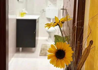 a vase with a yellow flower in a bathroom at Villa con Piscina in Ventimiglia di Sicilia
