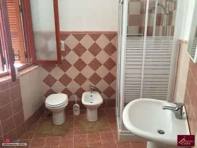 a bathroom with a toilet and a bidet and a sink at Villino Rosa in Santa Flavia
