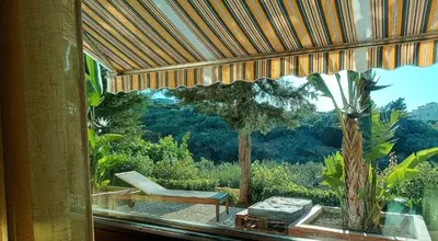 a room with a window with a chair and a table at Sea View Holiday in Altavilla Milicia