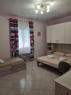 a living room with two beds and a table at Casa Nadiia in Cinisi